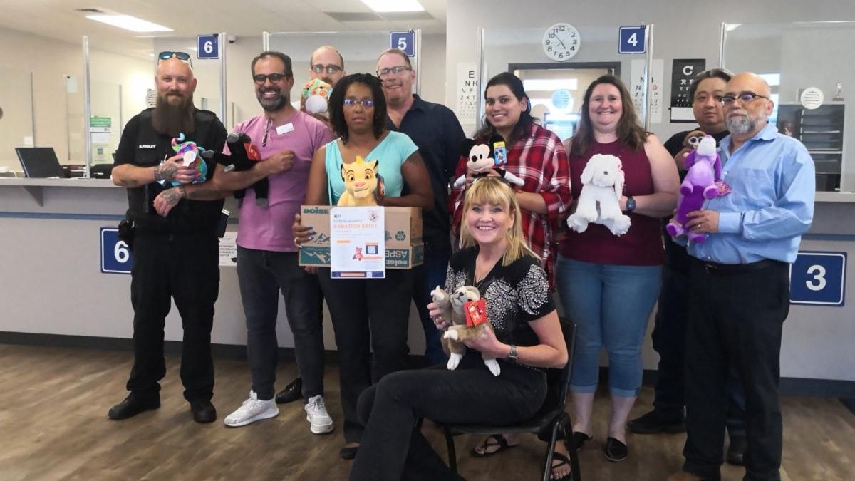 Group of people pose with donated stuffed animals