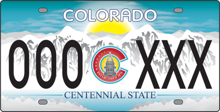 License plate of white snowy mountains and sun setting behind them. In the center is the Colorado logo with the state capitol building in the center.