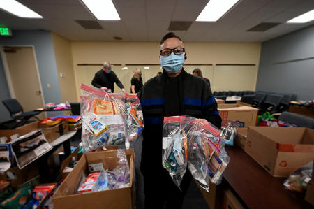 Division of Motor Vehicles Driver License Technician Kym Chavez shows off a personal-hygiene bags filled with staff-donations on Monday, Dec. 6 at Colorado Department of Revenue (DOR) headquarters in Lakewood. DOR Team Members donated almost 9,000 winter items to Volunteers of America, Veterans Program  for homeless and at-risk U.S. military veterans. (Derek Kuhn/Colorado DOR Photo) 