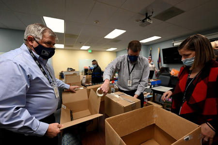 Division of Motor Vehicles Senior Director and U.S. Army veteran Mike Dixon (left), Taxation Division Tax Conferee Bill Laird and Marijuana Enforcement Division Criminal Investigator Tori Gavito (right) organize and pack donations on Monday, Dec. 6 at Colorado Department of Revenue (DOR) headquarters in Lakewood. DOR Team Members donated almost 9,000 winter items to Volunteers of America, Veterans Program  for homeless and at-risk U.S. military veterans. (Derek Kuhn/Colorado DOR Photo) 