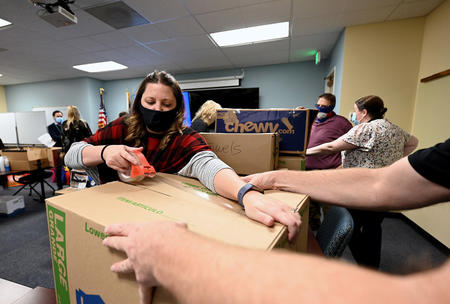 Taxation Division Customer Contact Agent Sarah Morgan tapes a box of donated items on Monday, Dec. 6 at Colorado Department of Revenue (DOR) headquarters in Lakewood. DOR Team Members donated almost 9,000 winter items to Volunteers of America, Veterans Program  for homeless and at-risk U.S. military veterans. (Derek Kuhn/Colorado DOR Photo) 