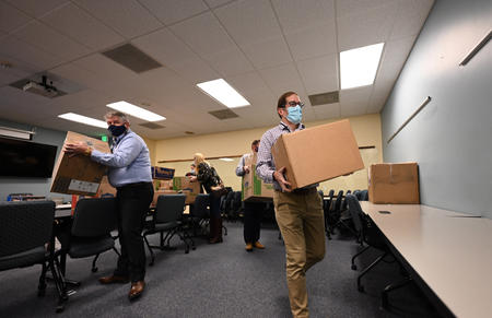 Division of Motor Vehicles Senior Director and U.S. Amy veteran Mike Dixon (left) and Department of Revenue (DOR) Executive Director Mark Ferrandino carry boxes of donations to the staging area  on Monday, Dec. 6 at Colorado Department of Revenue (DOR) headquarters in Lakewood. DOR Team Members donated almost 9,000 winter items to Volunteers of America, Veterans Program  for homeless and at-risk U.S. military veterans. (Derek Kuhn/Colorado DOR Photo) 