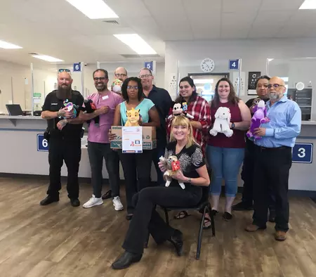 Division of Motor Vehicle Team Members from the Parker Driver License Office smile as they display stuffed animals collected for KOSI 101.1’s Teddy Bear Patr</body></html>