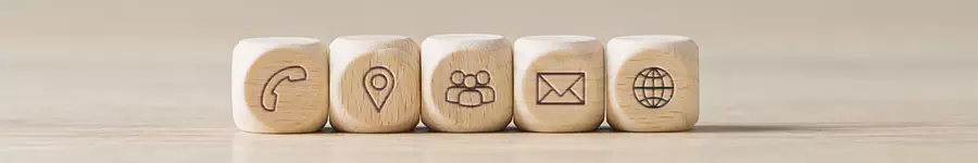 five natural wood dice lined up in a row with communication icons stamped into them.